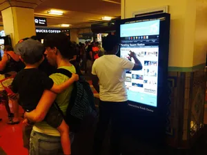 Riders exploring the Station Guide kiosk at the Union Station 75th Anniversary launch