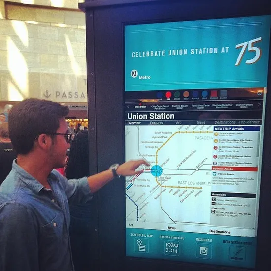 A rider using the Metro Station Guide touchscreen at Union Station